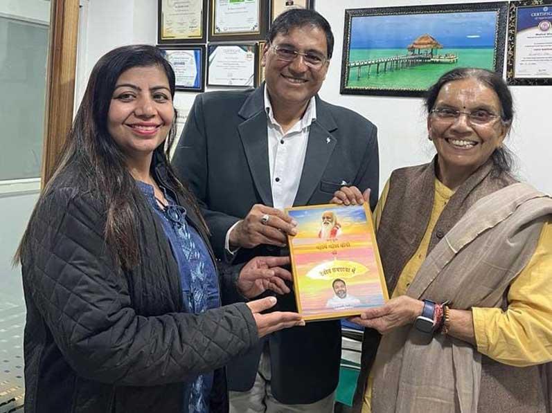 Smt. Rita Pandey, Regional Coordinator of Consciousness based Education presented the book ''Param Pujya Maharishi Mahesh Yogi ki Deviya Chhatra Chhaya me Brahmachari Girish'' to Dr. Rajeev Goel M.D. Medicine, President of Indian Medical Association Bareilly Branch.
