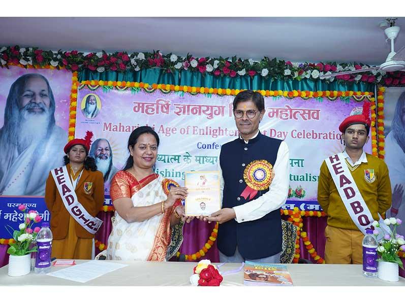 Smt Bhavana Tiwari, Principal Maharishi Vidya Mandir Shahdol  presented the book ''Param Pujya Maharishi Mahesh Yogi ki Daiviya Chhatrachhaya mein Brahmachari Girish'' to Hon'ble Vice Chancellor Pt.S.N.Shukla University Shahdol, Shri Ram Shankar Ji on Gyan Yug Diwas Celebration.